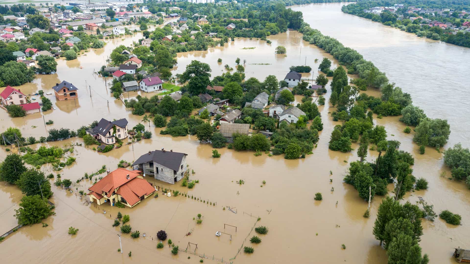 Casas unifamiliares en plena inundación por una crecida del río tras las lluvias, descubriremos las ventajas de un seguro de hogar frente a este tipo de fenómenos atmosféricos