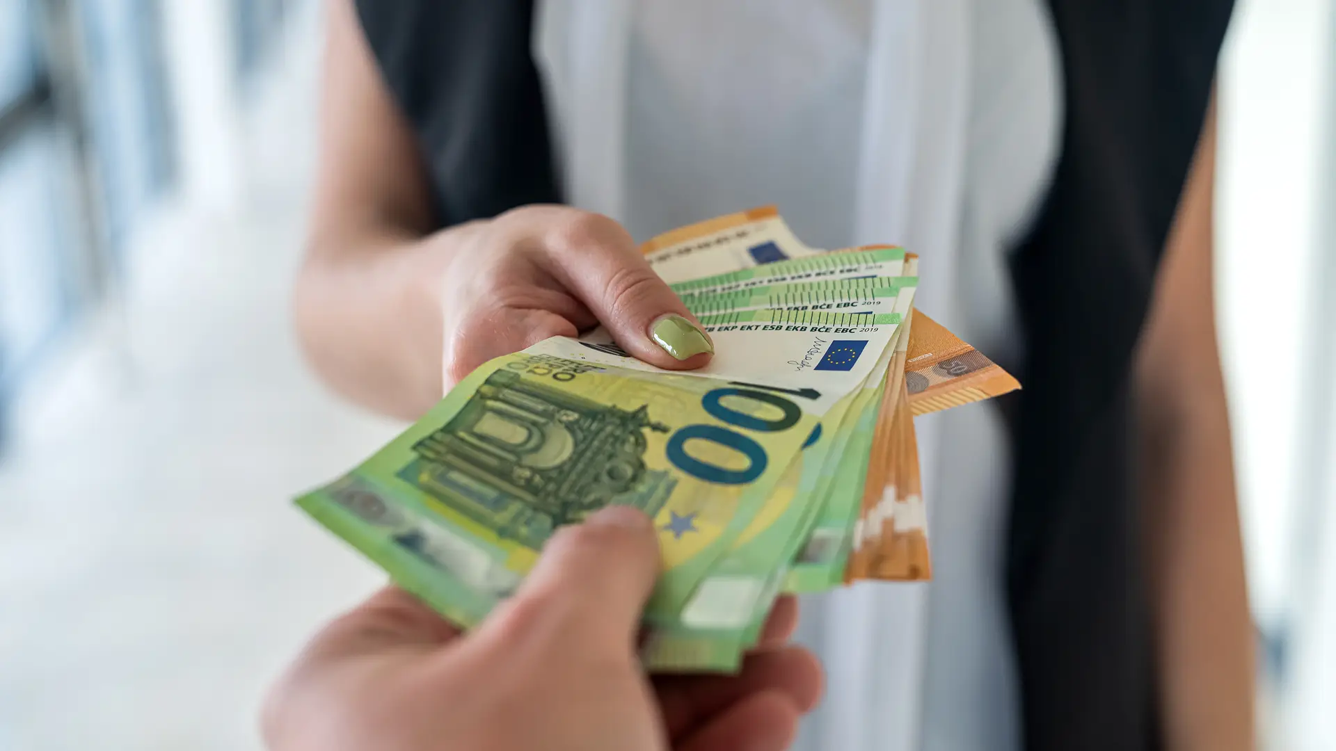 Una persona dándole dinero a otra por la indemnizacion de un daño en su hogar Una persona dándole dinero a otra por la indemnizacion de un daño en su hogar