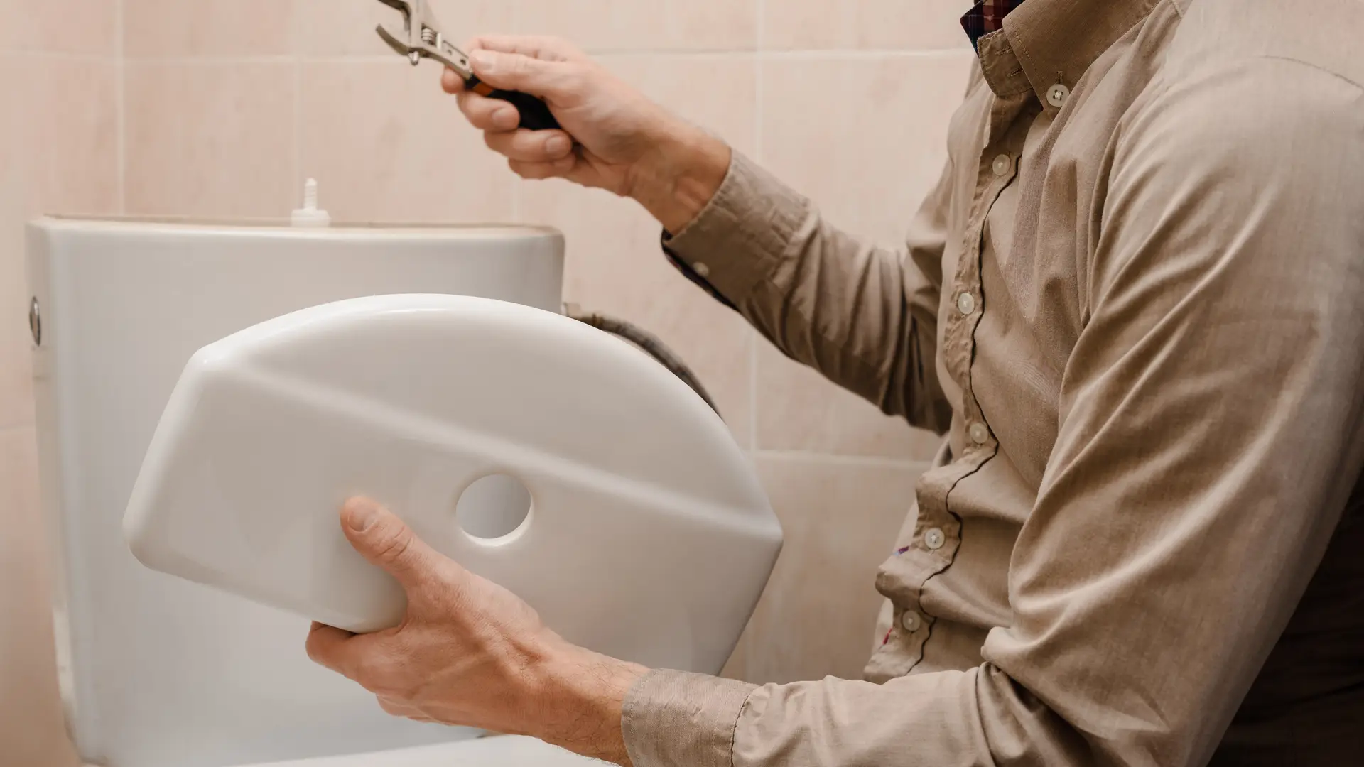 Un empleado arreglando el inodoro de un cliente que tiene un seguro del hogar que cubre ese tipo de arreglos