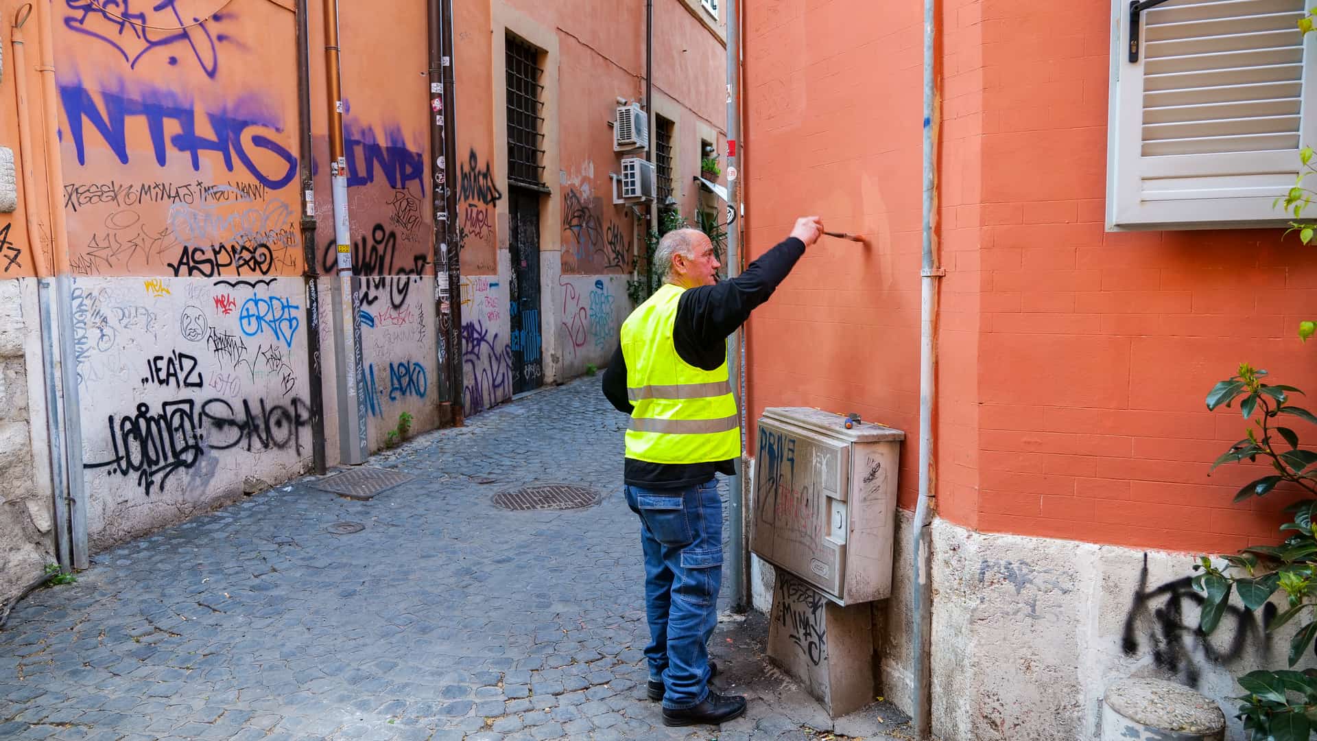 Técnico pintando fachada de cliente que tiene contratado seguro de hogar contra graffitis Técnico pintando fachada de cliente que tiene contratado seguro de hogar contra graffitis