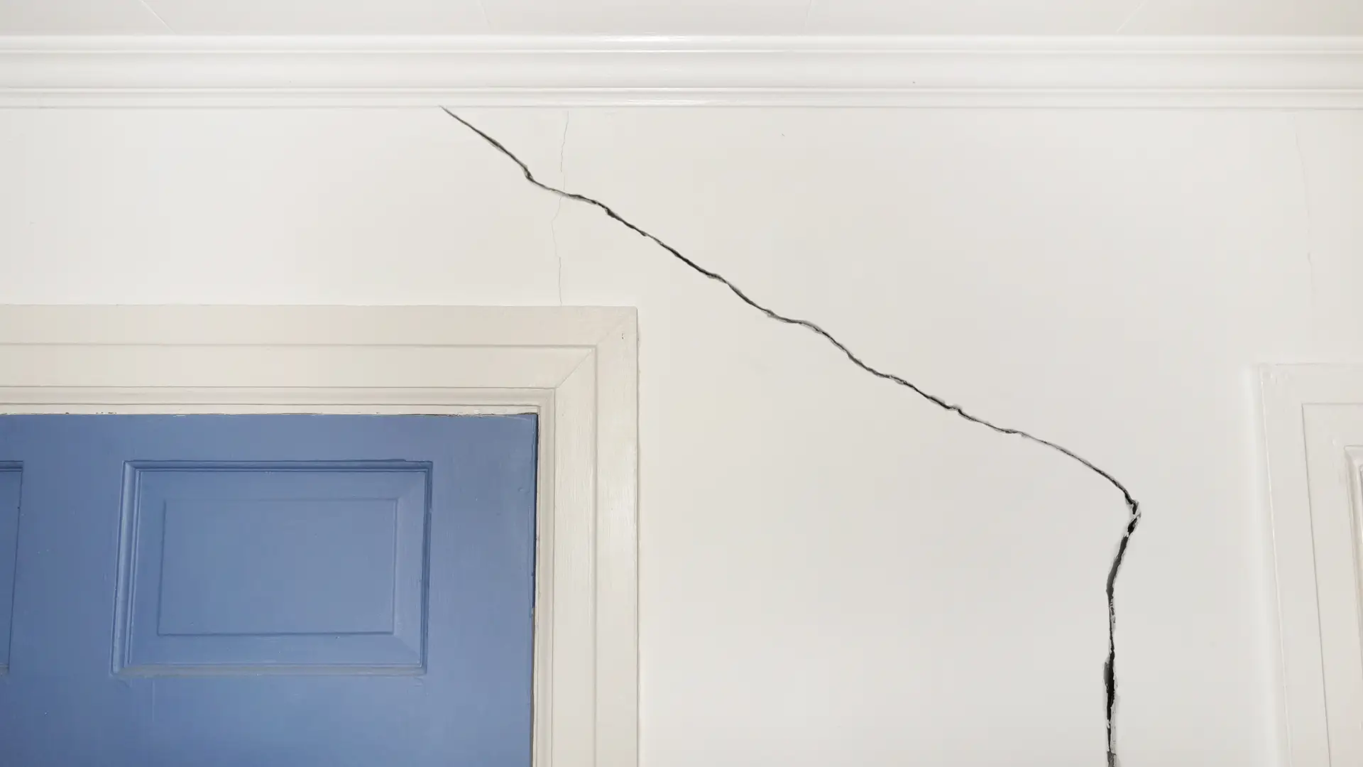 Pared de casa con seguro de hogar agrietada debido a un terremoto Pared de casa con seguro de hogar agrietada debido a un terremoto