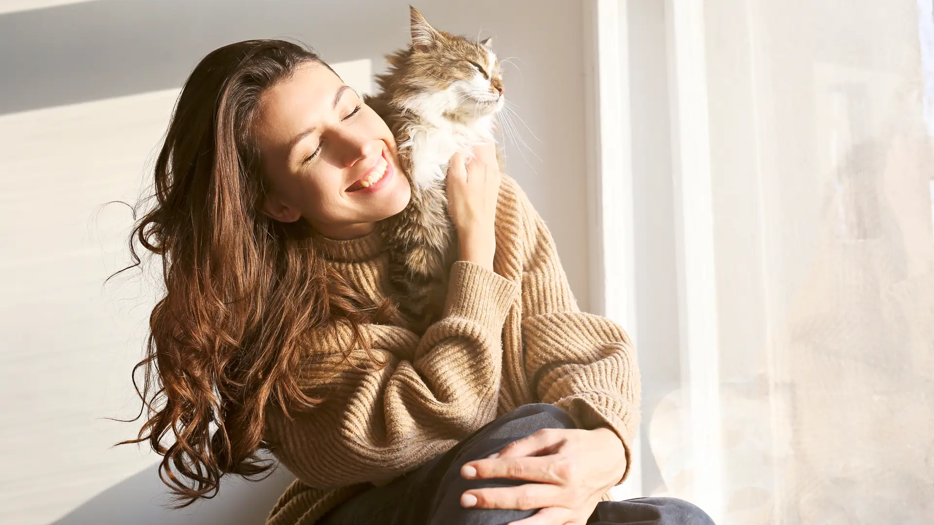 Persona feliz acariciando su gato con seguro de mascota contratado Persona feliz acariciando su gato con seguro de mascota contratado