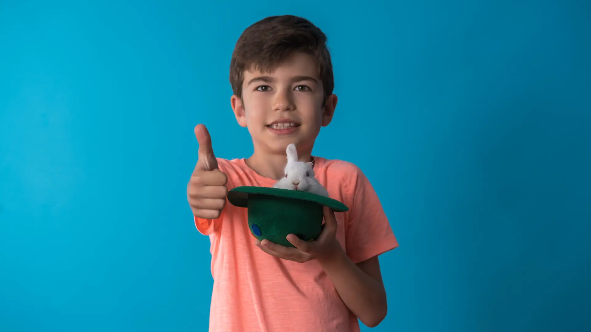 Joven con conejo dentro de sombrero y realizando gesto de ok sonriente para dar su opinión sobre seguro de mascota Joven con conejo dentro de sombrero y realizando gesto de ok sonriente para dar su opinión sobre seguro de mascota