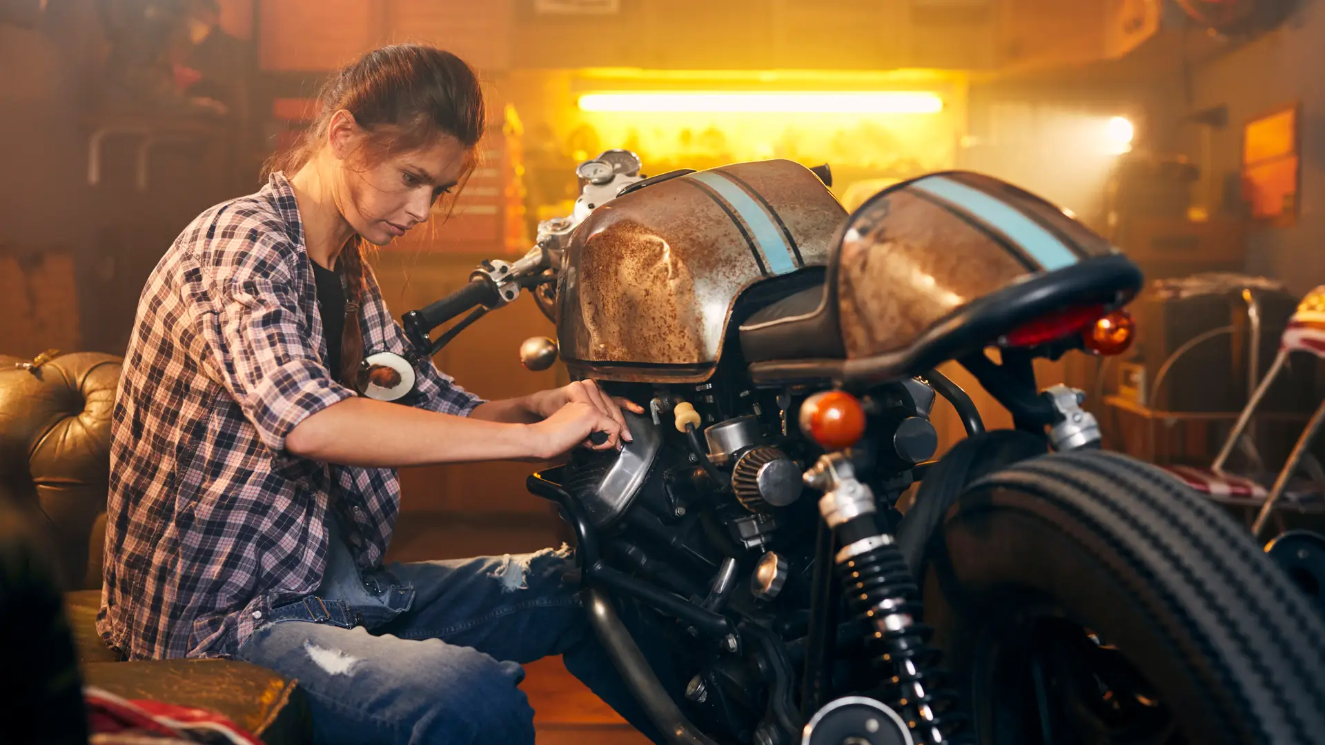 Mujer poniendo a punto su moto con seguro de motos clásicas