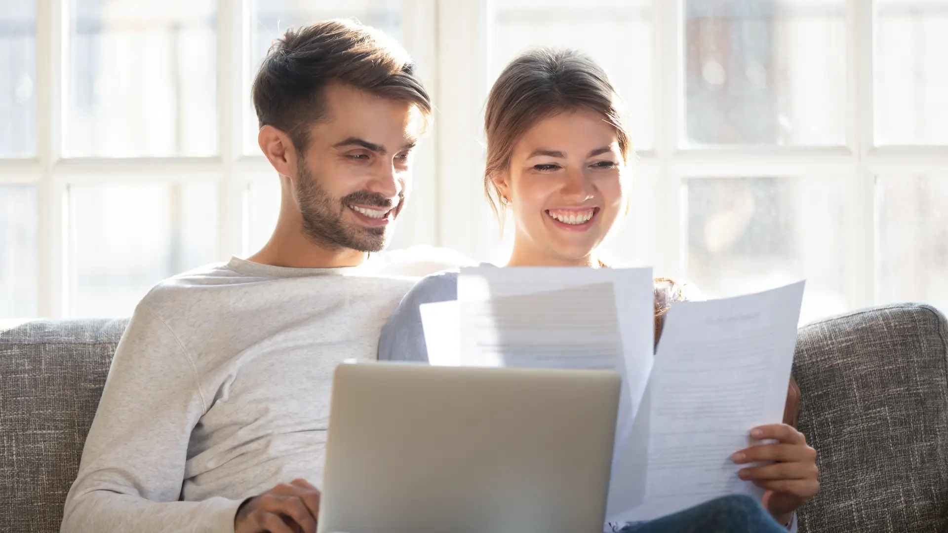 Una pareja joven revisando los papeles para cambiar de compañía su seguro de salud Una pareja joven revisando los papeles para cambiar de compañía su seguro de salud