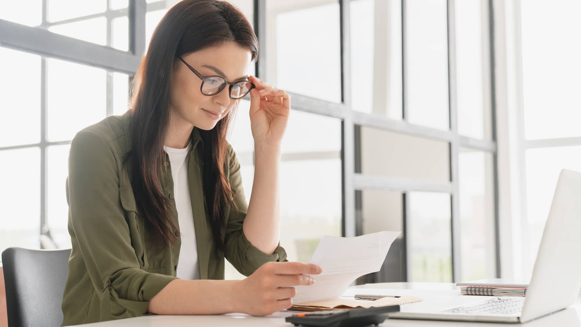 Mujer realizando declaración de la renta al cual ha añadido su seguro de salud ya que le desgrava Mujer realizando declaración de la renta al cual ha añadido su seguro de salud ya que le desgrava