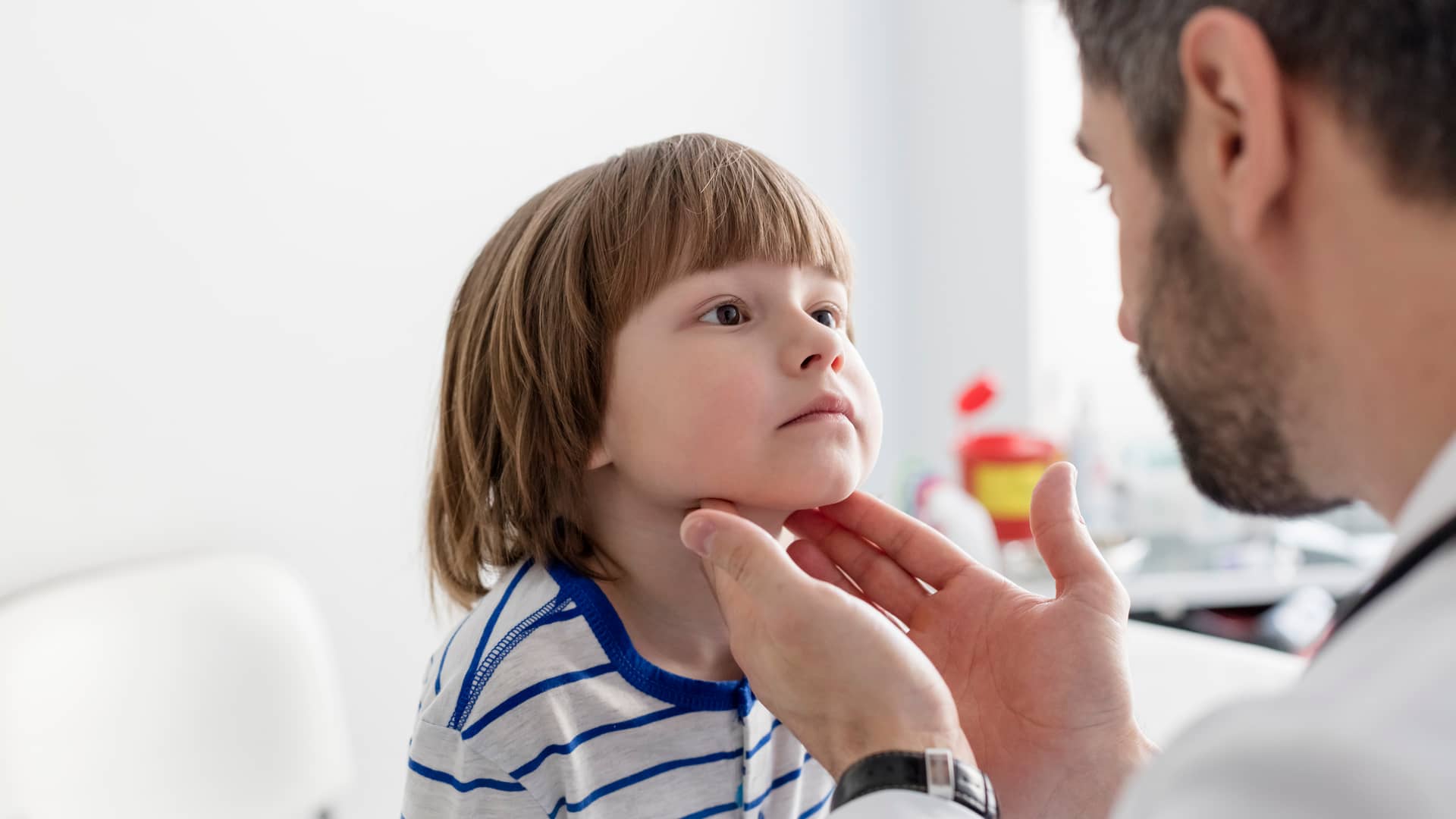 Niño simpático y agradable en la cita con su pediatra pasando revisión Niño simpático y agradable en la cita con su pediatra pasando revisión