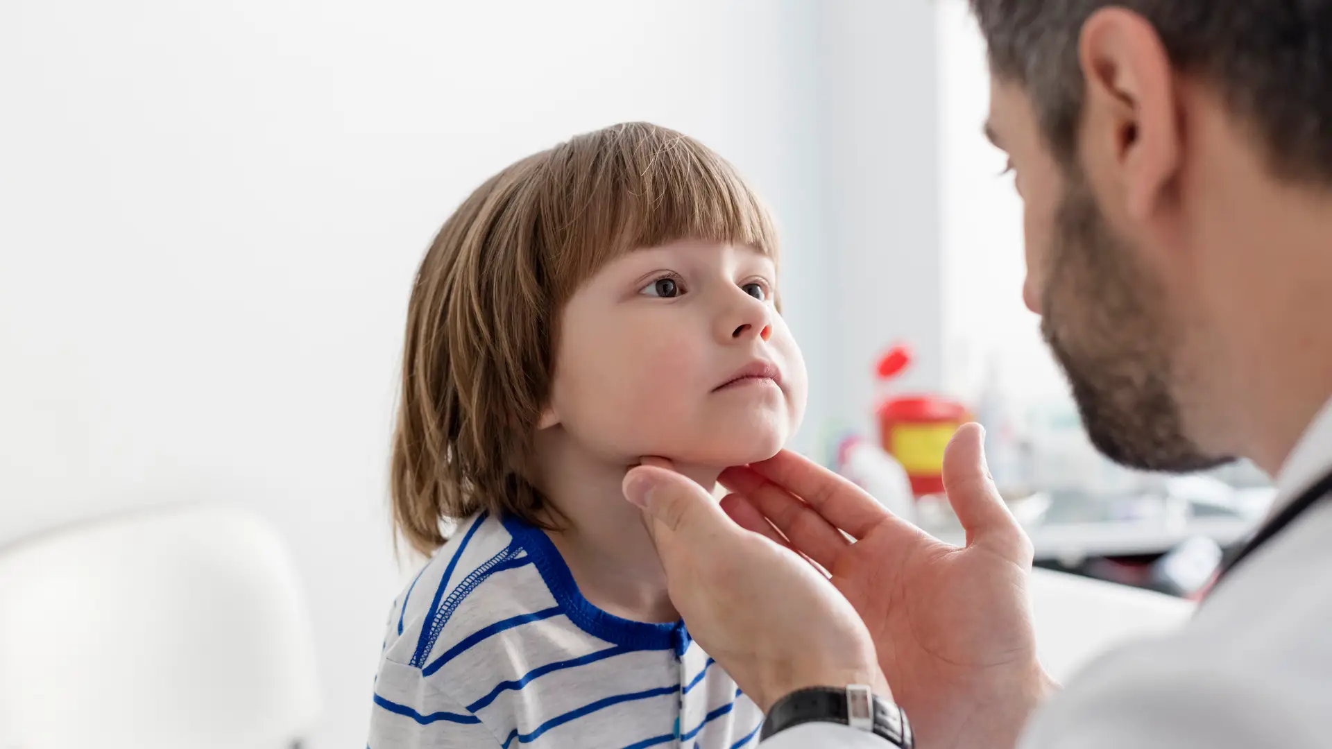 Niño simpático y agradable en la cita con su pediatra pasando revisión Niño simpático y agradable en la cita con su pediatra pasando revisión