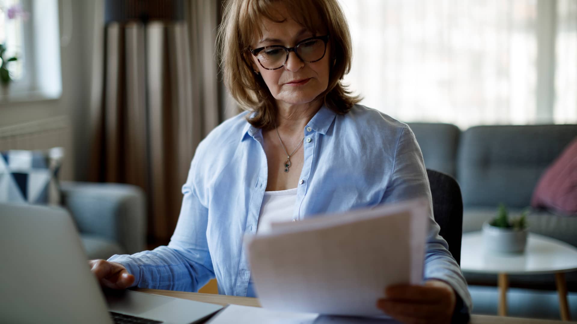 Mujer comparando factura de su seguro salud con el precio de otras compañias