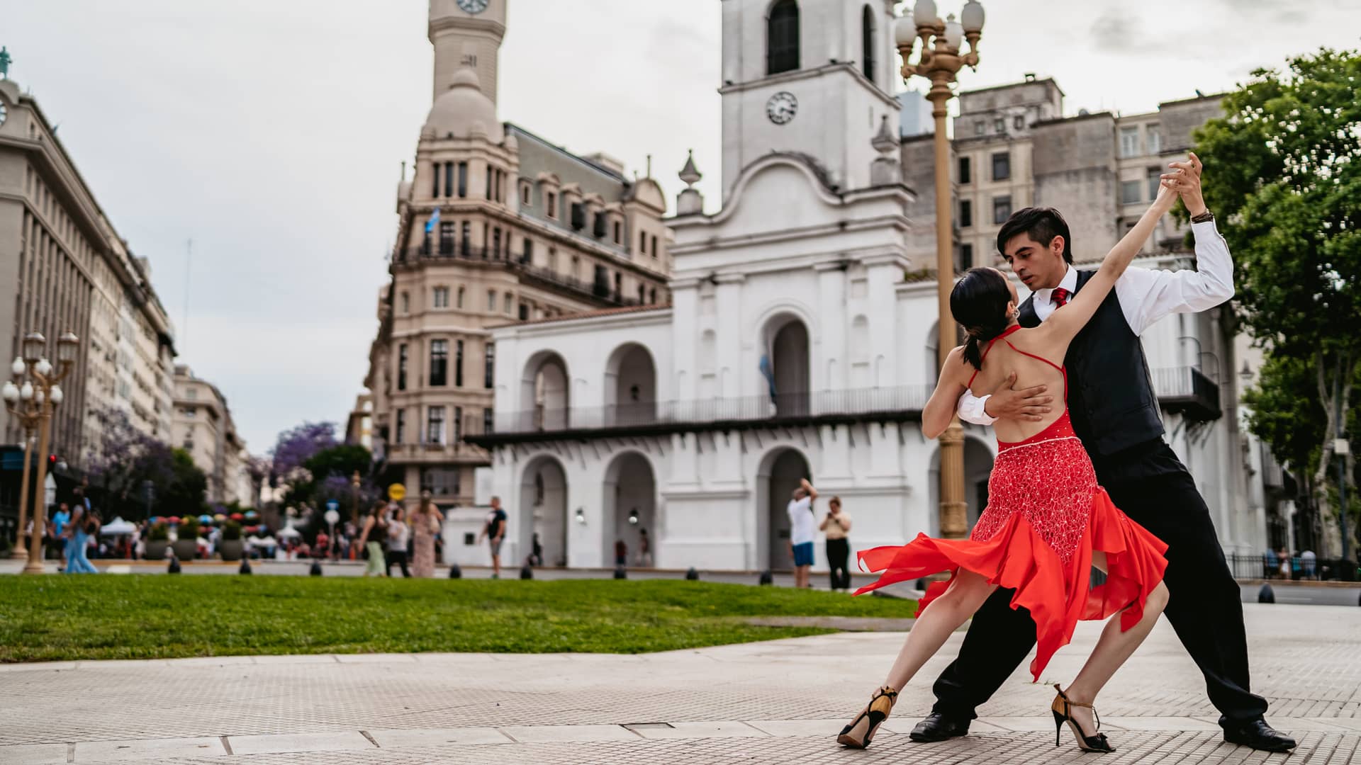 Pareja latina bailando tango en la plaza de la ciudad  de Buenos Aires para cuyo viaje se ha contratado un seguro