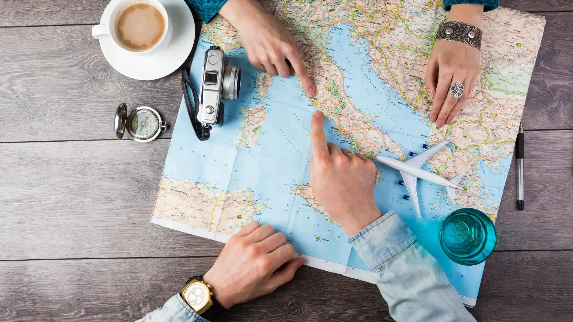 Gente planificando unas vacaciones con un mapa que busca un seguro de viaje barato Gente planificando unas vacaciones con un mapa que busca un seguro de viaje barato