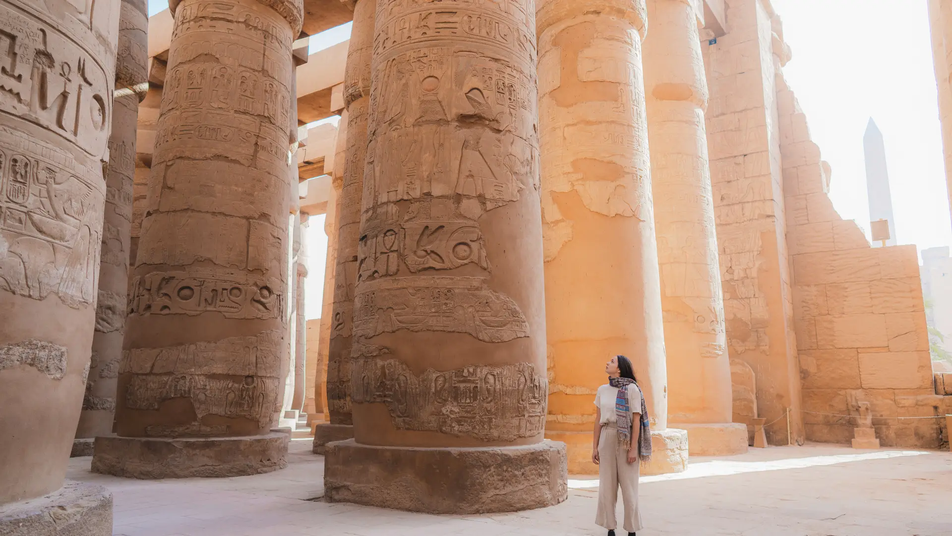 Mujer con seguro de viaje contratado caminando en el antiguo templo egipcio en Luxor en Egipto Mujer con seguro de viaje contratado caminando en el antiguo templo egipcio en Luxor en Egipto
