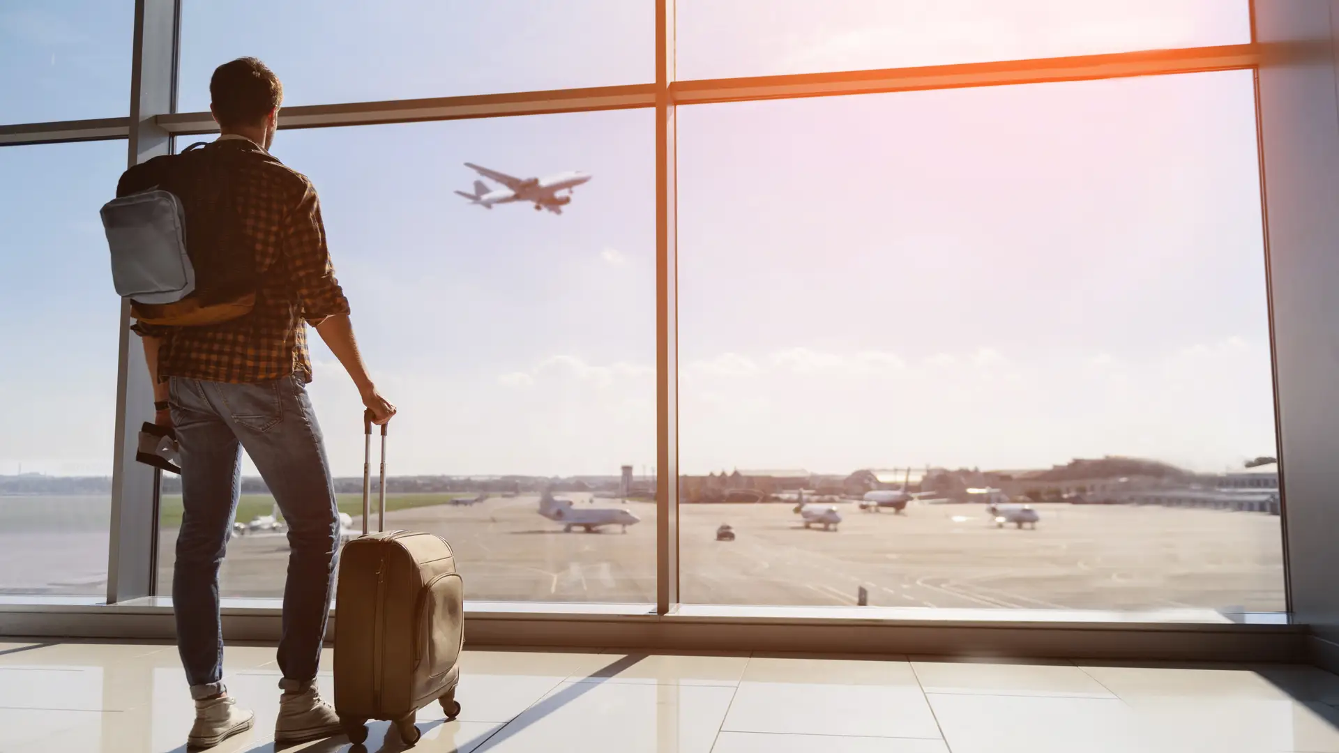 Joven esperando a coger su vuelo para irse de viaje con seguro contratado por si ocurre algun problema Joven esperando a coger su vuelo para irse de viaje con seguro contratado por si ocurre algun problema