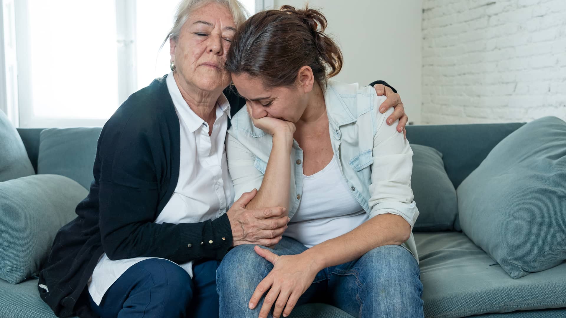 Madre e hija con seguro de vida llorando el fallecimiento de un familiar Madre e hija con seguro de vida llorando el fallecimiento de un familiar