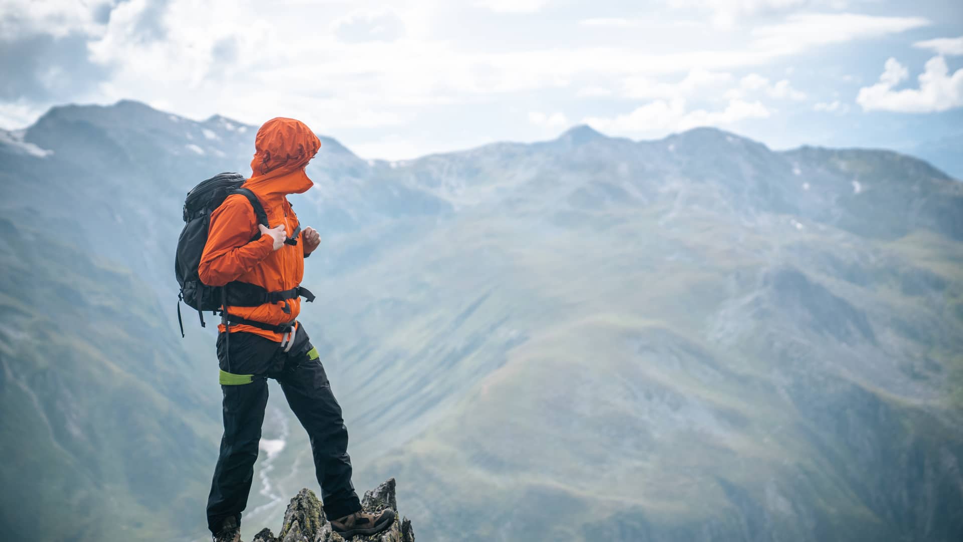 Hombre en lo alto de la montaña pensando qué es lo que cubre su seguro de vida Hombre en lo alto de la montaña pensando qué es lo que cubre su seguro de vida