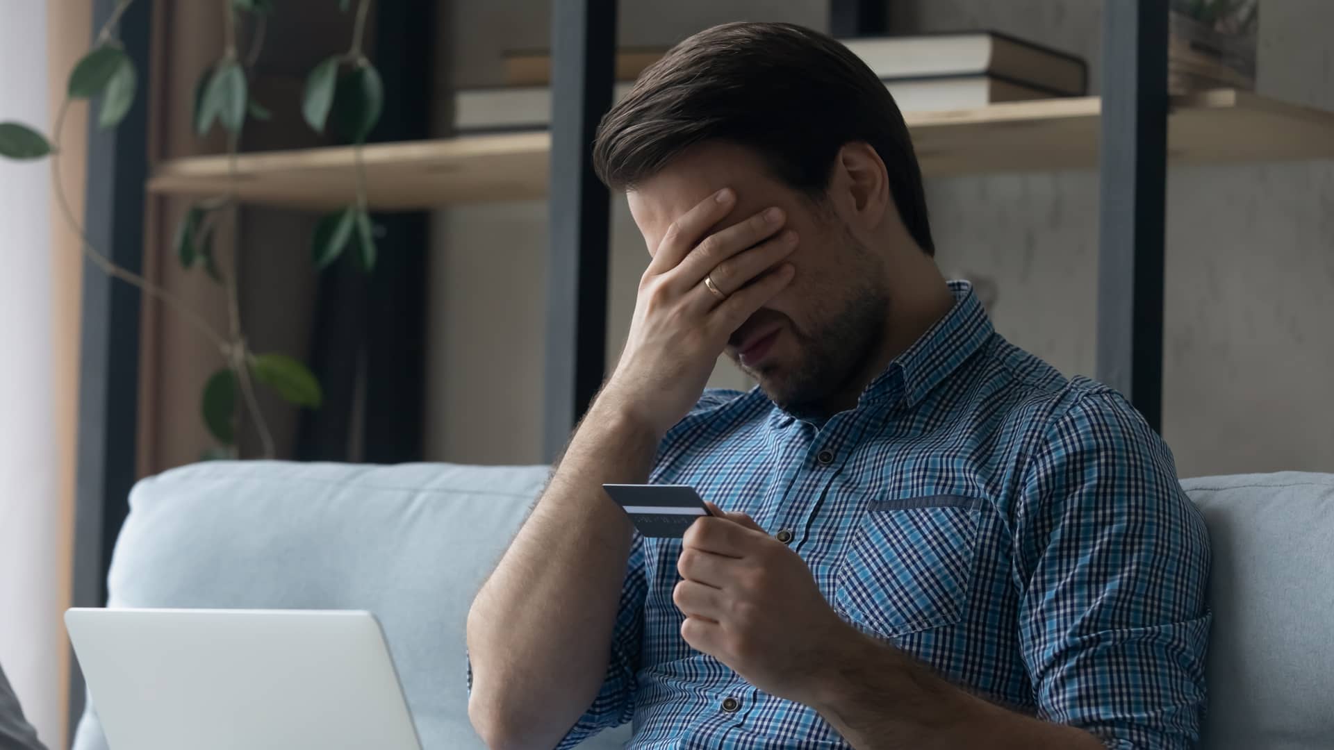 Un chico muy triste con su tarjeta de crédito porque no tiene un seguro de vida para protegerla Un chico muy triste con su tarjeta de crédito porque no tiene un seguro de vida para protegerla