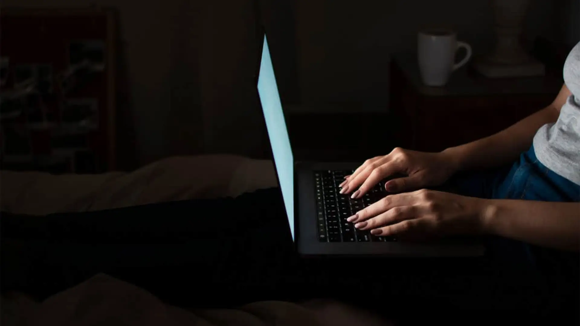 Persona tecleando en un ordenador portátil a oscuras como concepto de ciberseguridad y navegación nocturna.