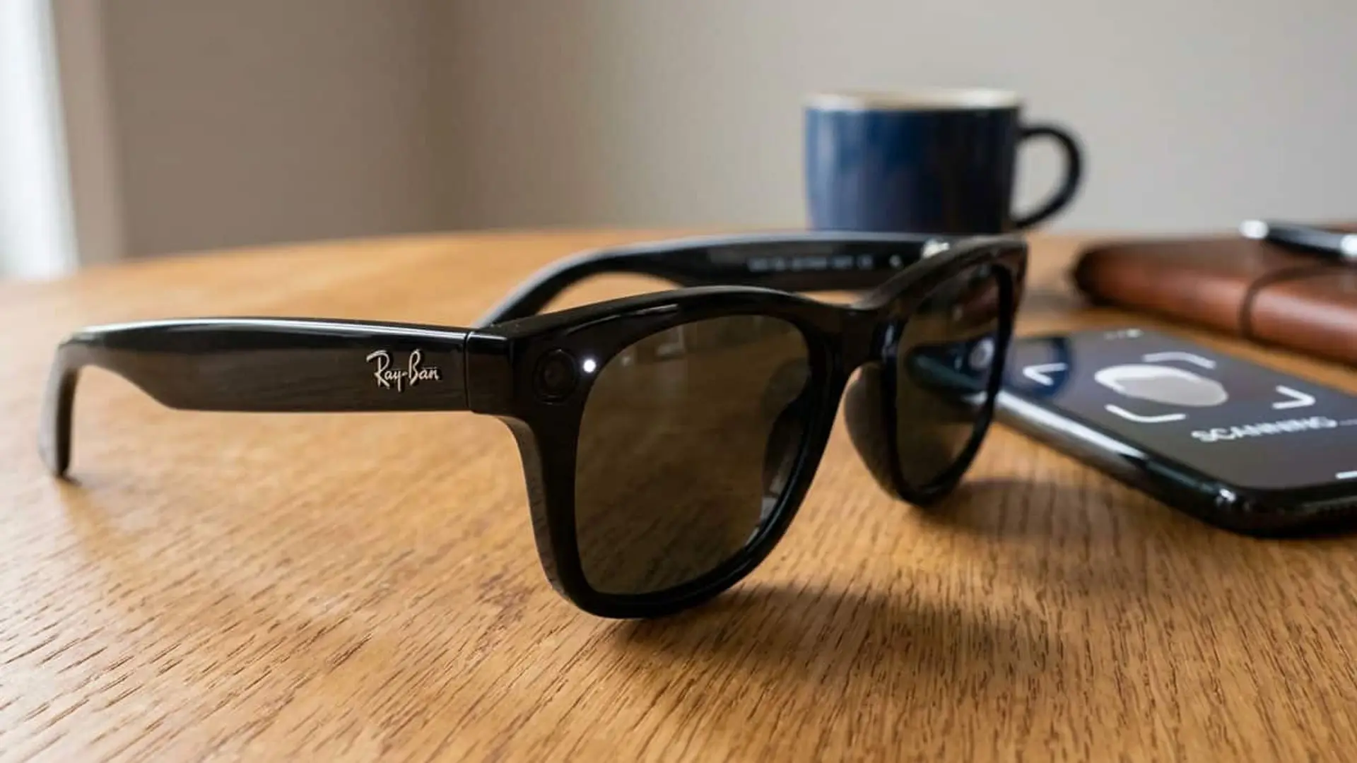 La patente de Meta que preocupa: gafas capaces de identificarte y grabarte sin que lo consientas Gafas Ray-Ban Meta negras con cámara integrada junto a un teléfono móvil sobre una mesa