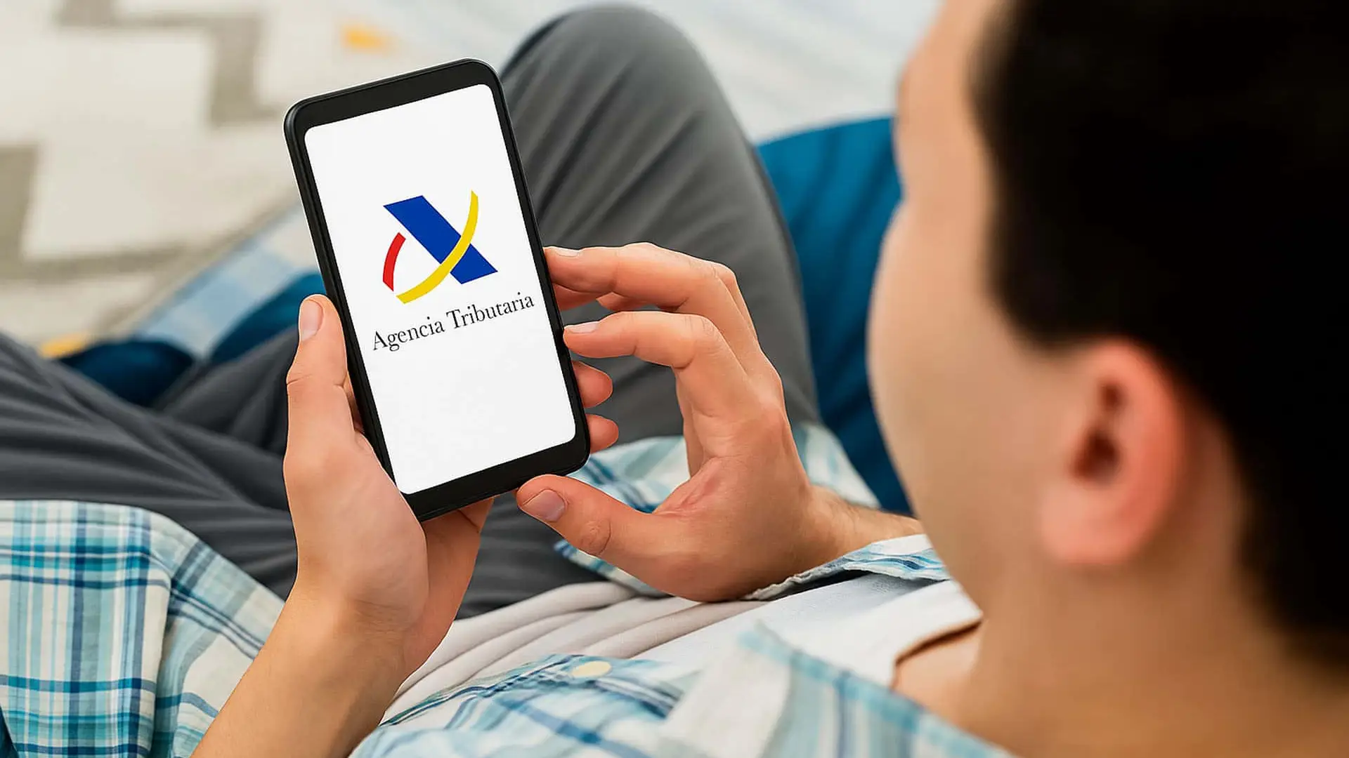 Contribuyente consultando la app de la Agencia Tributaria en su móvil para hacer trámites de la Renta o gestionar sus impuestos.