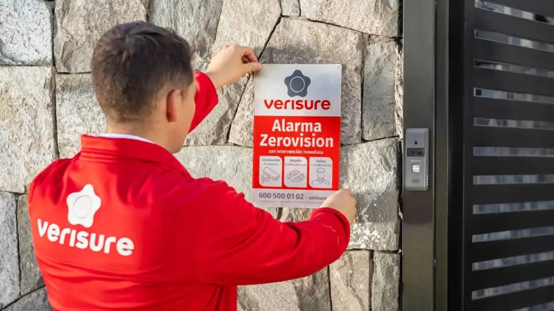 Verisure se corona como la empresa de alarmas más valiosa del mundo: así queda el top-3 Técnico de Verisure colocando un cartel de alarma en la entrada de una vivienda.