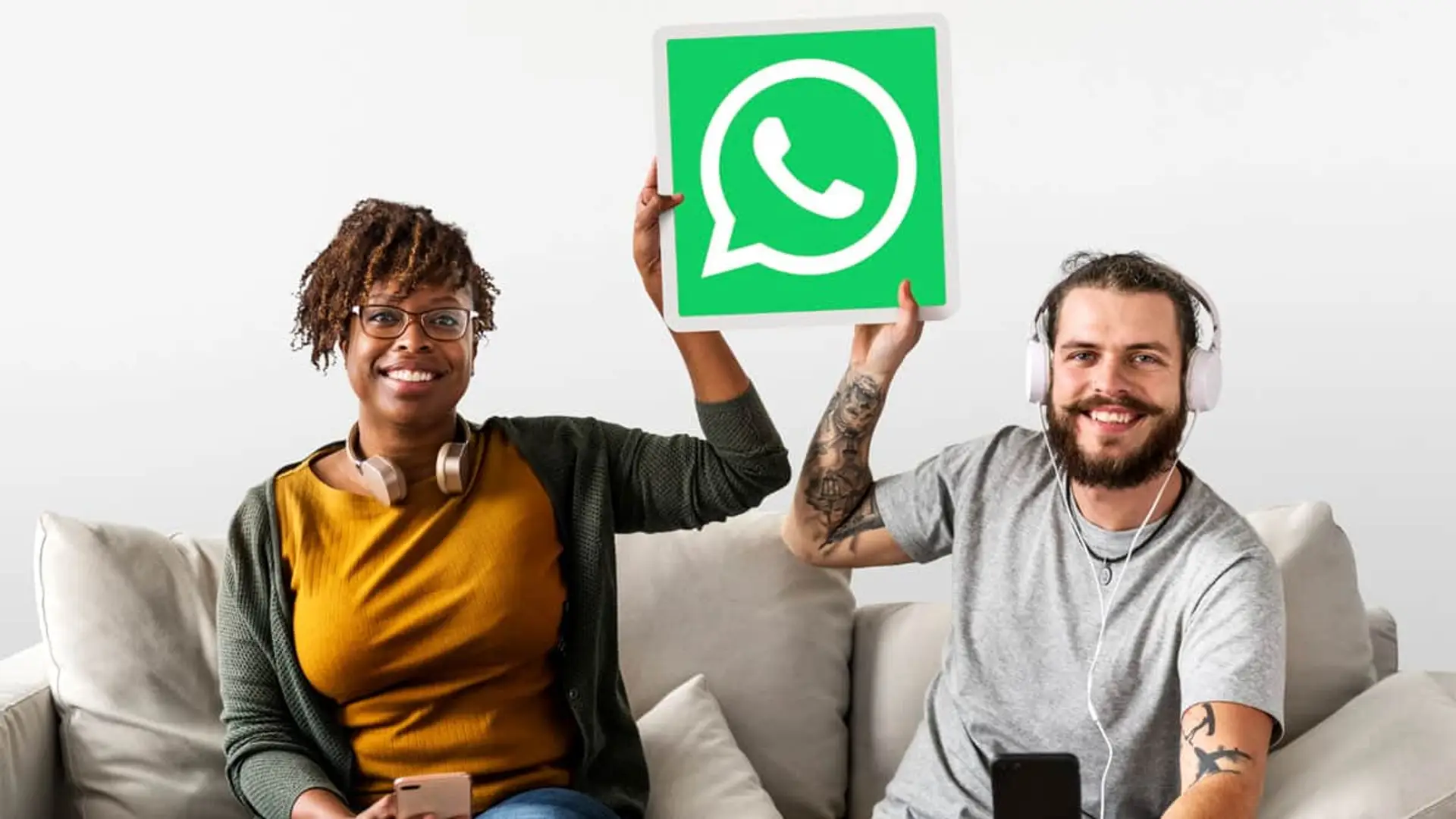 WhatsApp activa un nuevo modo de seguridad para frenar hackeos con un solo toque Pareja joven y diversa en un sofá, mostrando el logo de la app WhatsApp.