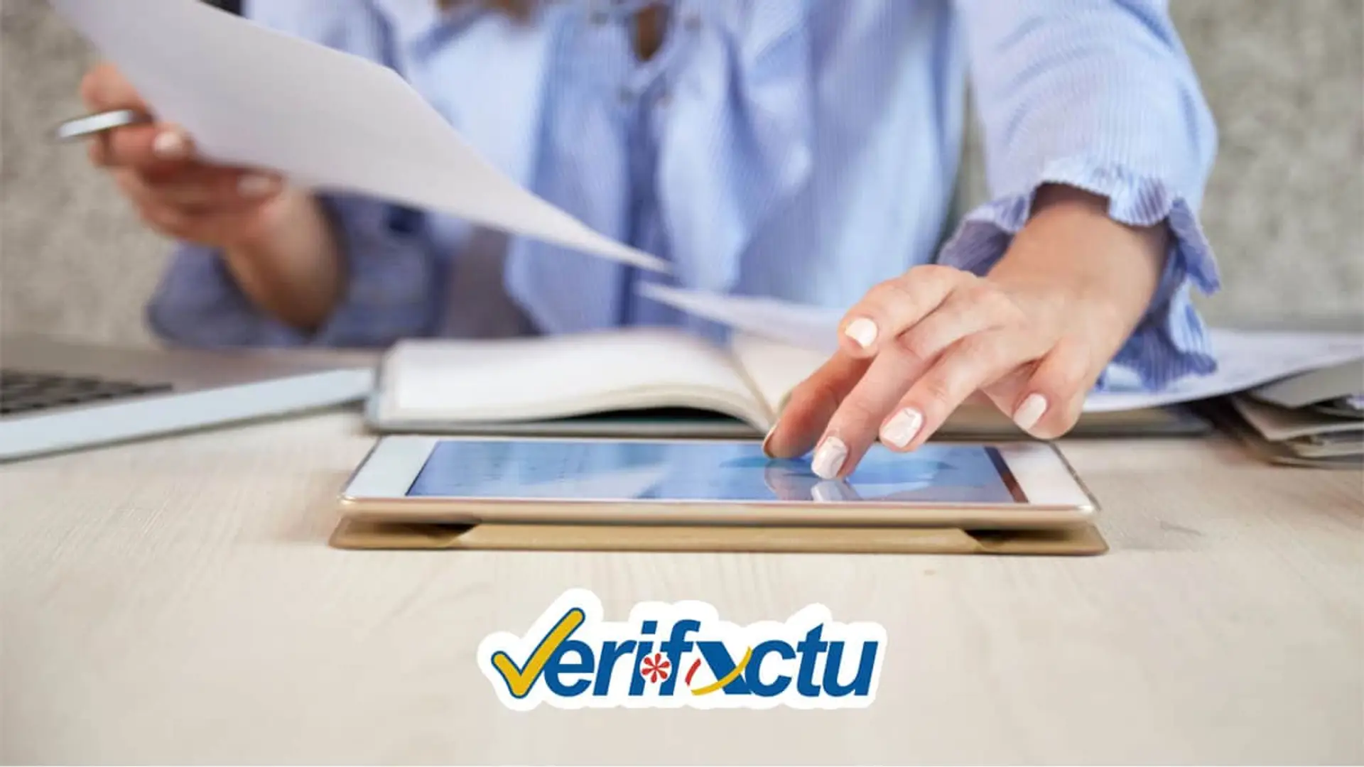 VeriFactu, la revolución fiscal que inquieta a los expertos en ciberseguridad Profesional gestionando facturas con una tablet. Logo de Verifactu, el sistema de facturación electrónica de la Agencia Tributaria.