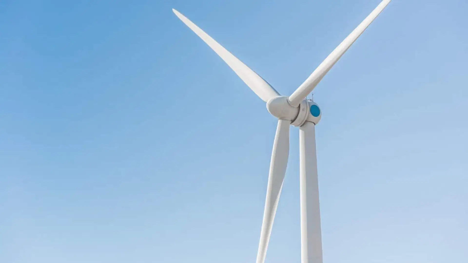 Aerogenerador de energía eólica con cielo despejado, símbolo de la producción de electricidad renovable