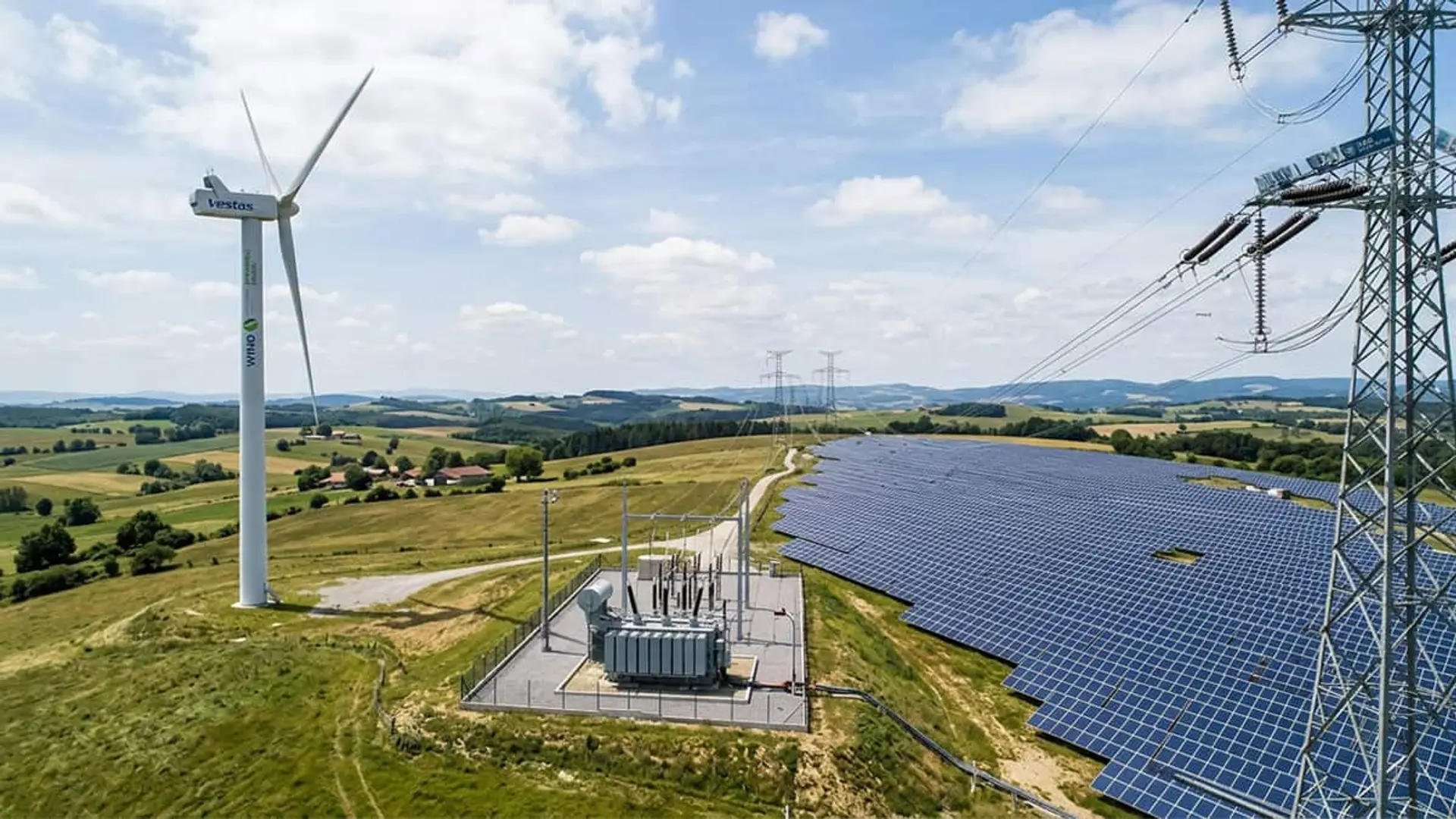 El precio de la luz en España es la mitad que en Europa gracias al viento y el sol: por qué tu factura no lo nota Aerogenerador, paneles solares y líneas eléctricas en un paisaje rural