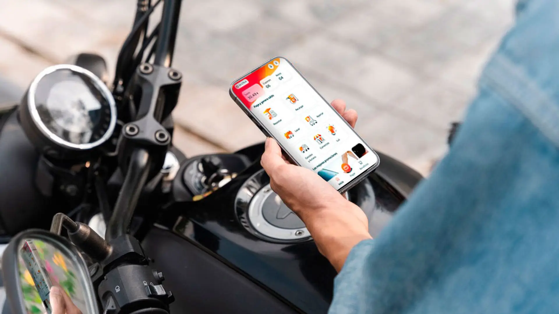 Repsol rebaja hasta 40 céntimos el litro en Semana Santa: el truco es Waylet y cuántos contratos tienes con ellos Usuario utilizando la app Waylet en el móvil junto a una moto para gestionar pagos y servicios.