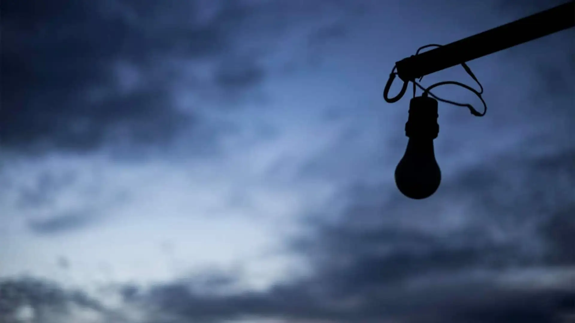 El informe final del apagón destapa cinco fallos clave: de Red Eléctrica al autoconsumo doméstico Bombilla apagada colgando contra un cielo oscuro al atardecer, simbolizando un corte de luz.