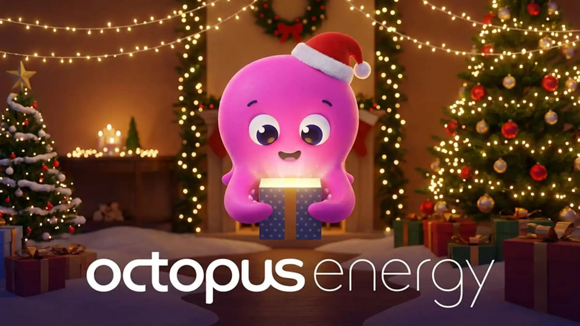 Publicidad de Navidad de Octopus Energy. Su mascota, un pulpo rosa, abre un regalo brillante en un salón decorado.