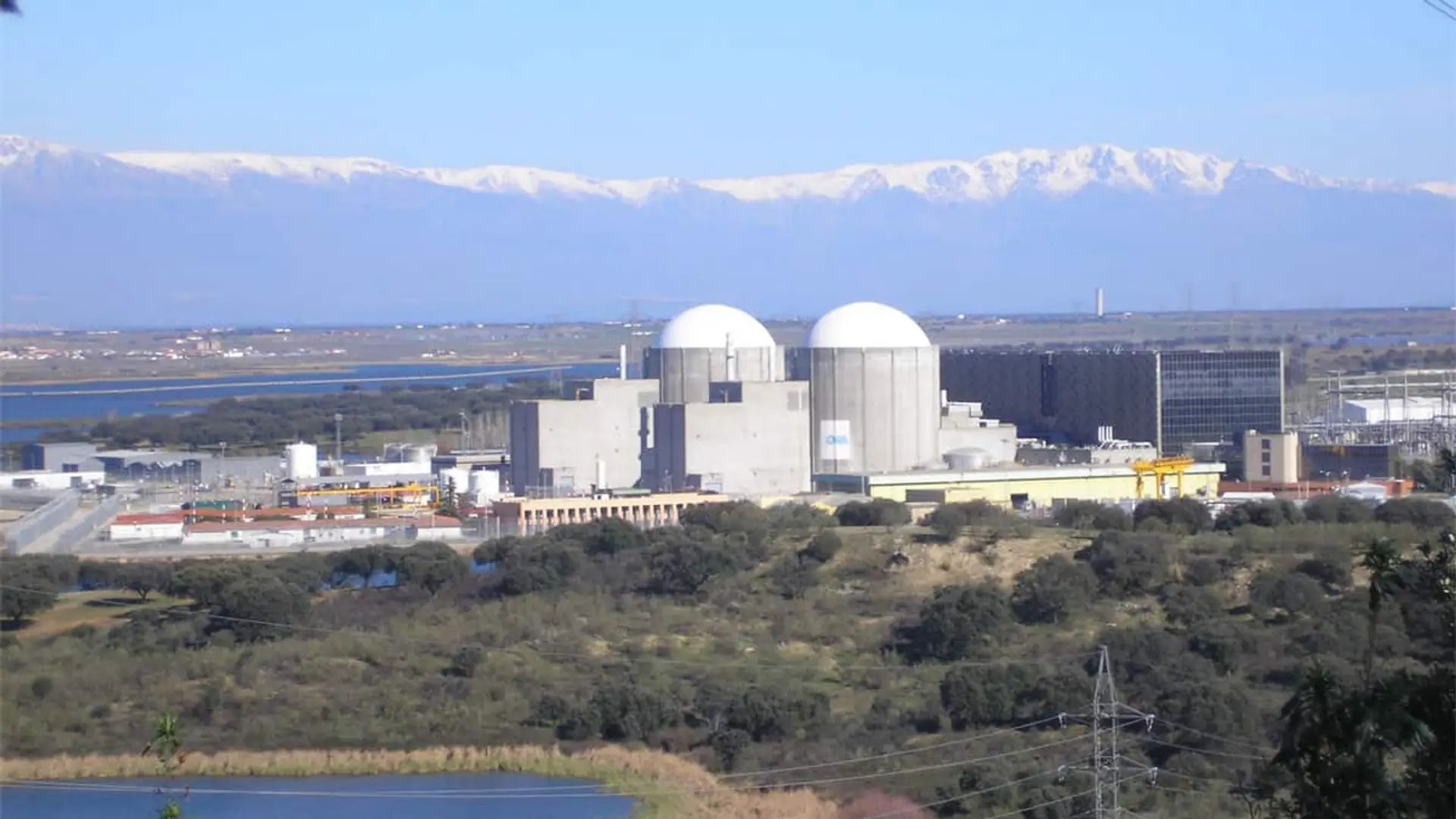 Panorámica de la central nuclear de Almaraz con las montañas nevadas al fondo.