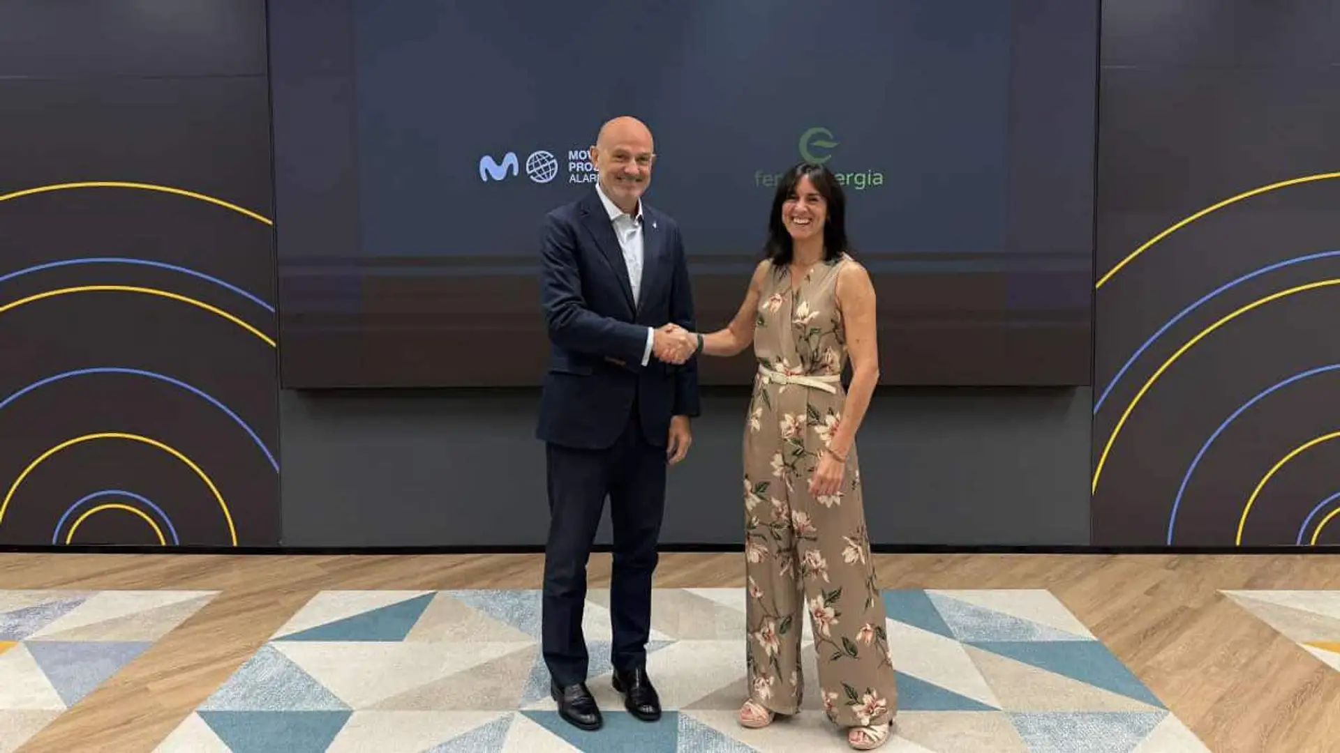 Movistar Prosegur Alarmas llega a Feníe Energía con condiciones exclusivas valoradas en hasta 240 euros Dos directivos de Feníe Energía y Movistar Prosegur Alrmas dándose la mano en un acto corporativo frente a una pantalla con logotipos al fondo