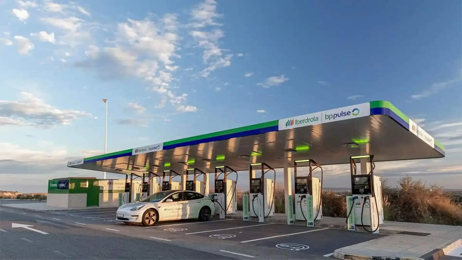 Estación de recarga de Iberdrola bp pulse al aire libre con un coche eléctrico cargando