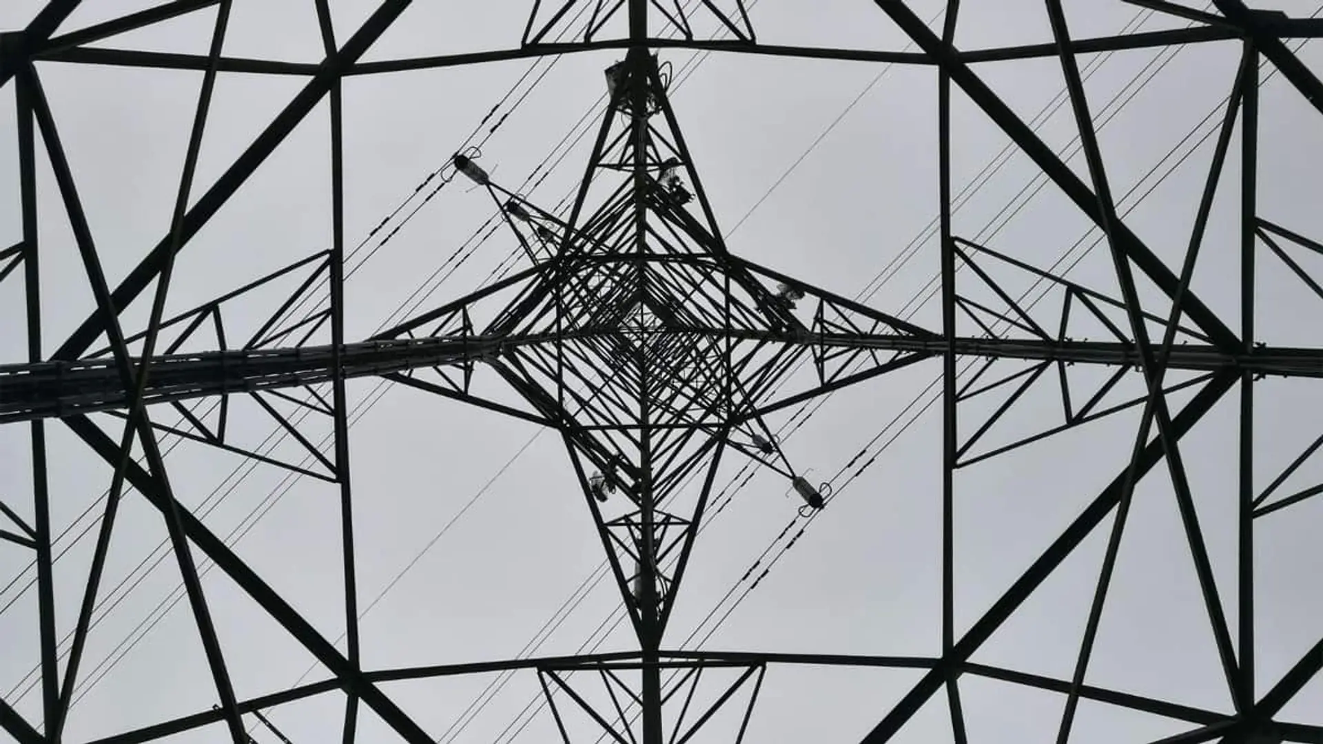 Vista desde abajo del interior de una torre de alta tensión mostrando su estructura metálica simétrica