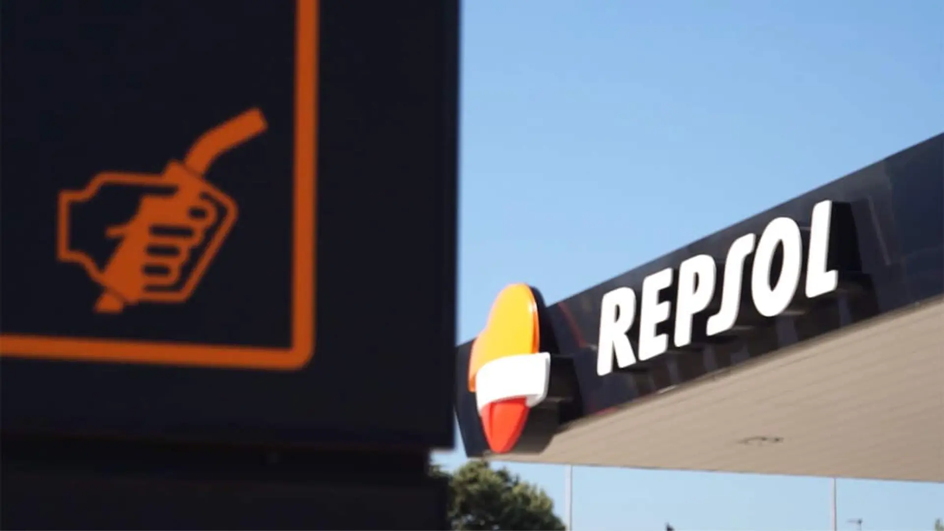 Logotipo de Repsol en una estación de servicio junto a una señal de surtidor de combustible.