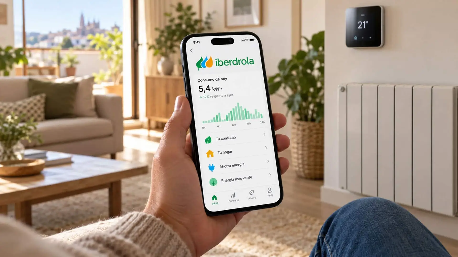 Persona consultando el consumo eléctrico en la app de Iberdrola desde su móvil, junto a un radiador y un termostato digital.