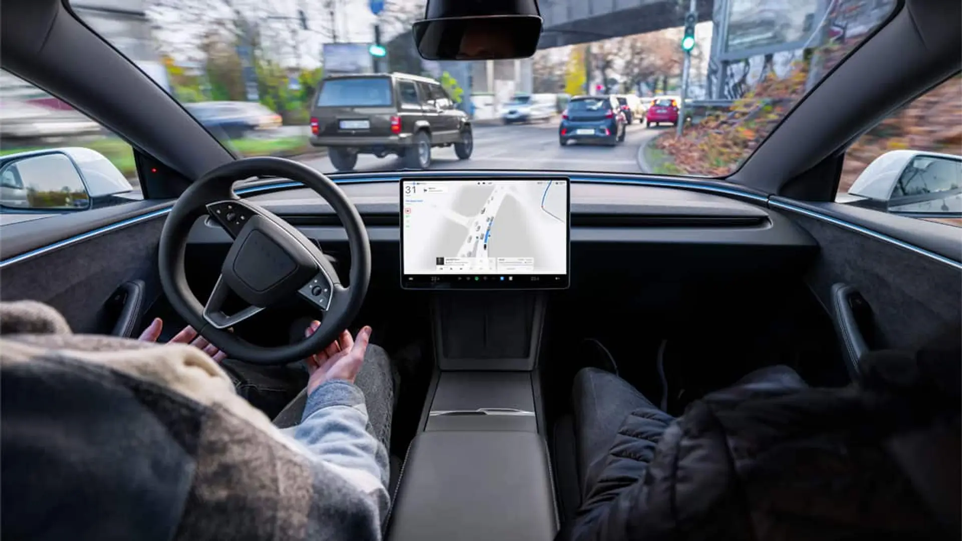 Los Tesla ya conducen solos por España: ciudades, fechas y cómo apuntarse a las pruebas de conducción autónoma Interior de coche eléctrico con pantalla central y sistema de conducción asistida circulando por ciudad