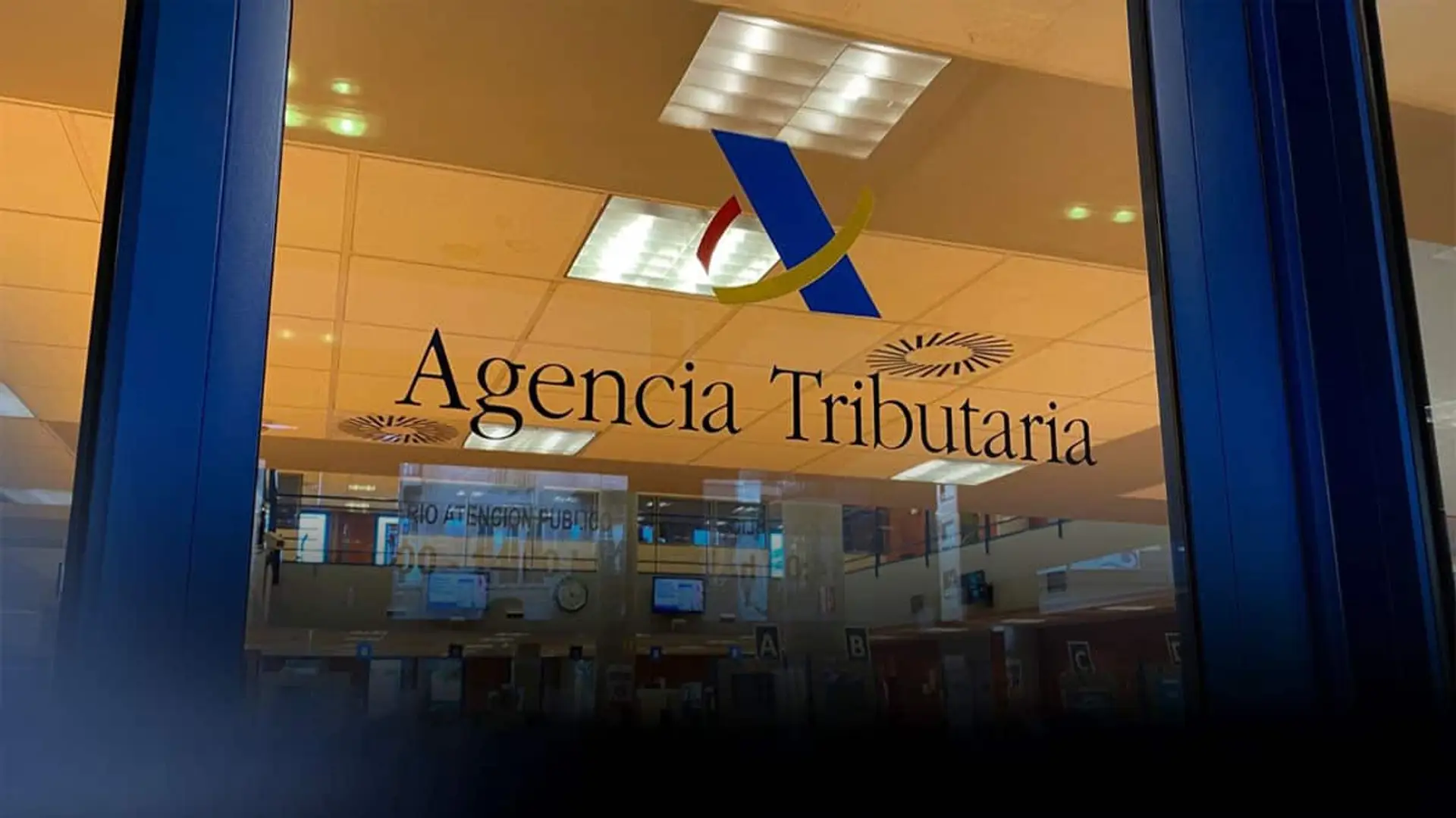 ¿Dudas con tus impuestos? Hacienda prepara su propio Google para encontrar respuestas fiscales sin llamar a nadie Entrada de una oficina de la Agencia Tributaria con el logotipo oficial visible en el acceso al área de atención al público.
