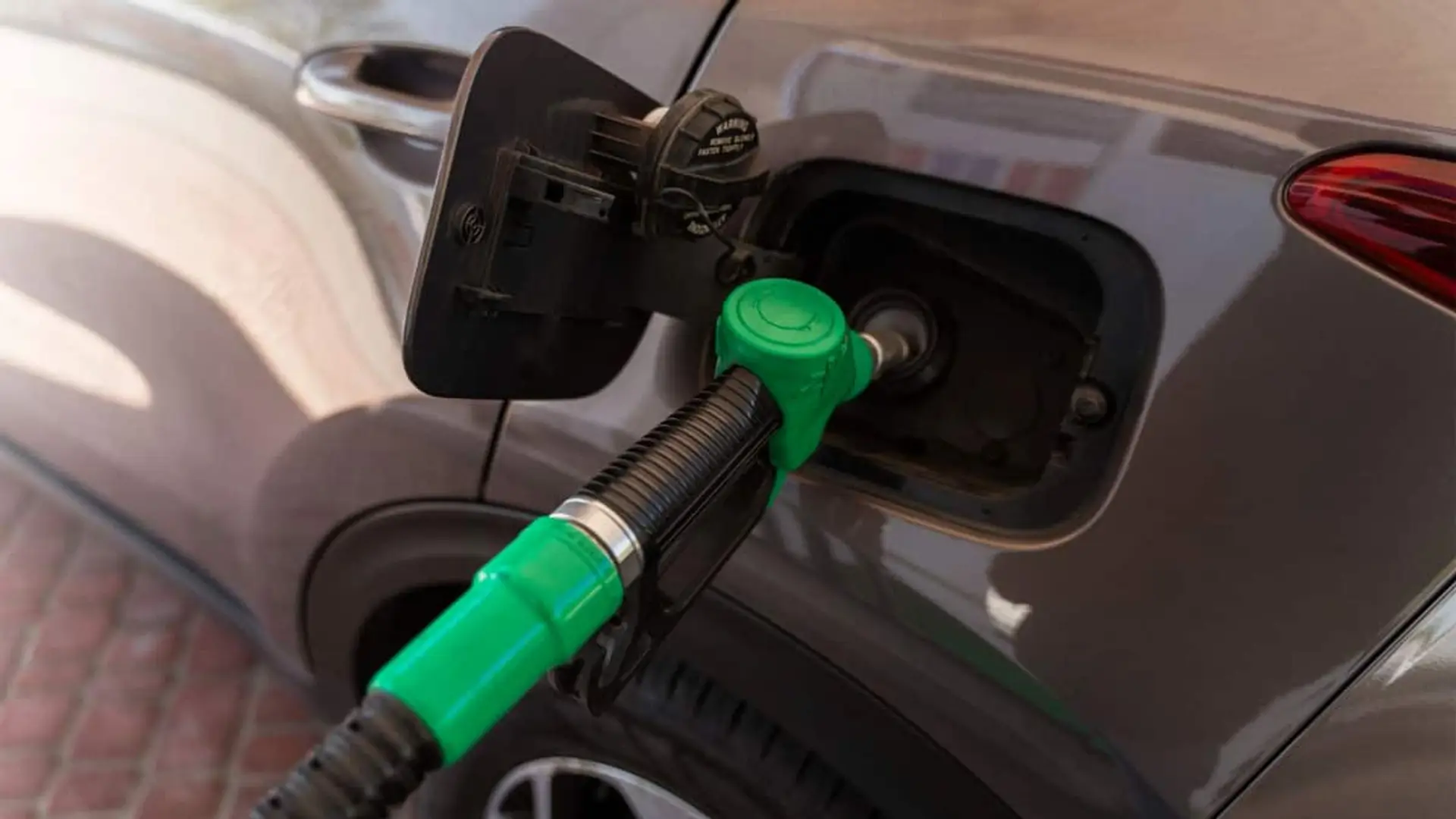 Manguera de combustible verde repostando un coche en primer plano
