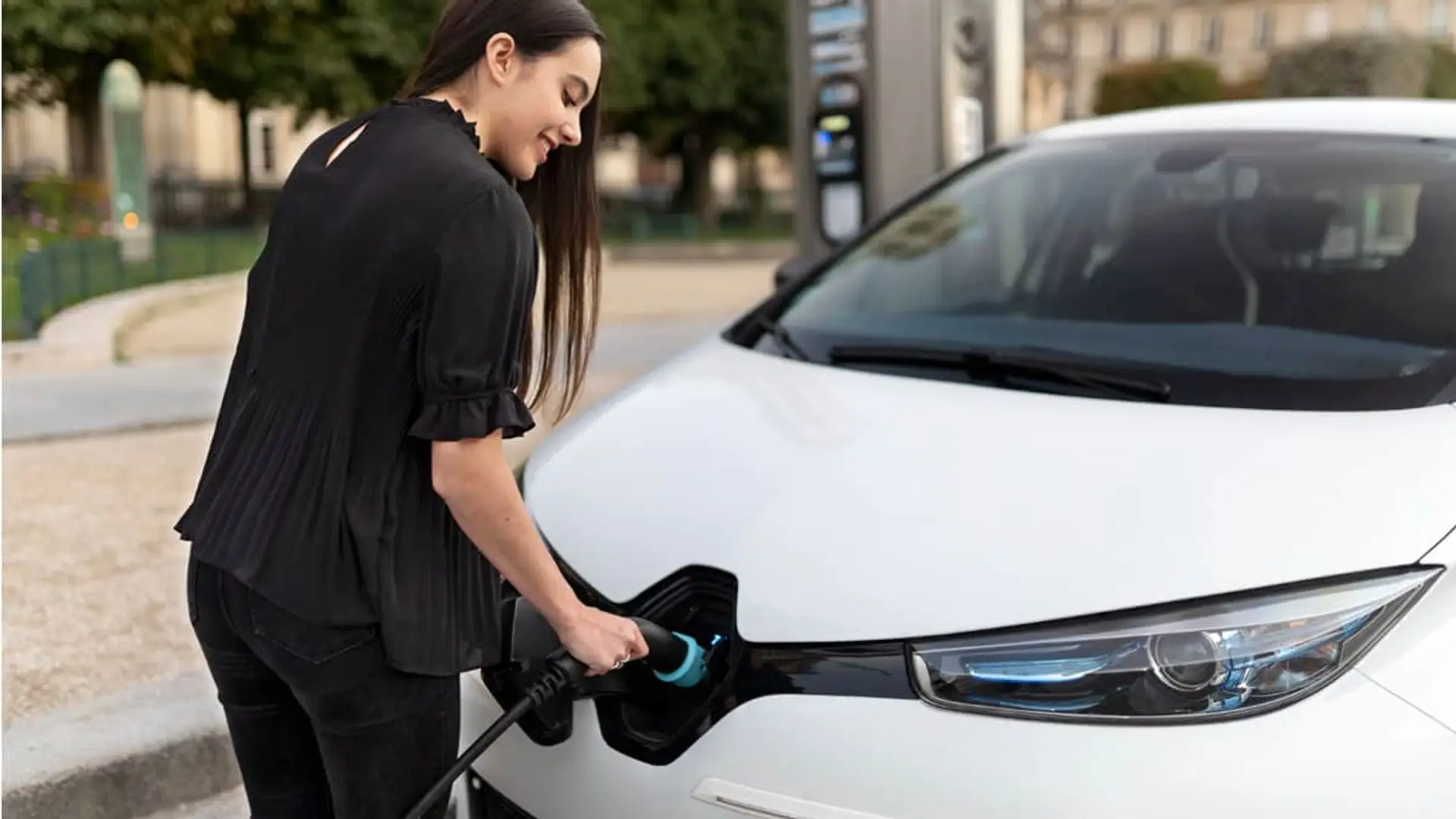 Frenazo al coche eléctrico: el 22% de cargadores no funciona y solo el 4% son ultrarrápidos Una mujer carga su coche eléctrico en la calle.