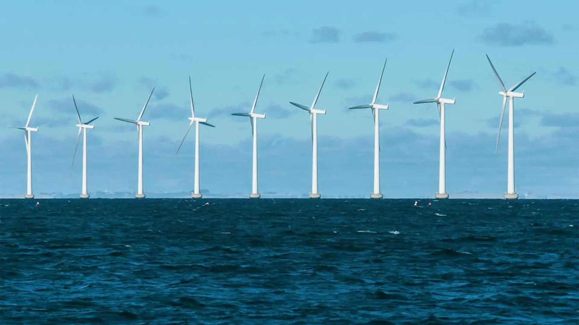 Parque eólico marino con varios aerogeneradores instalados en el mar abierto