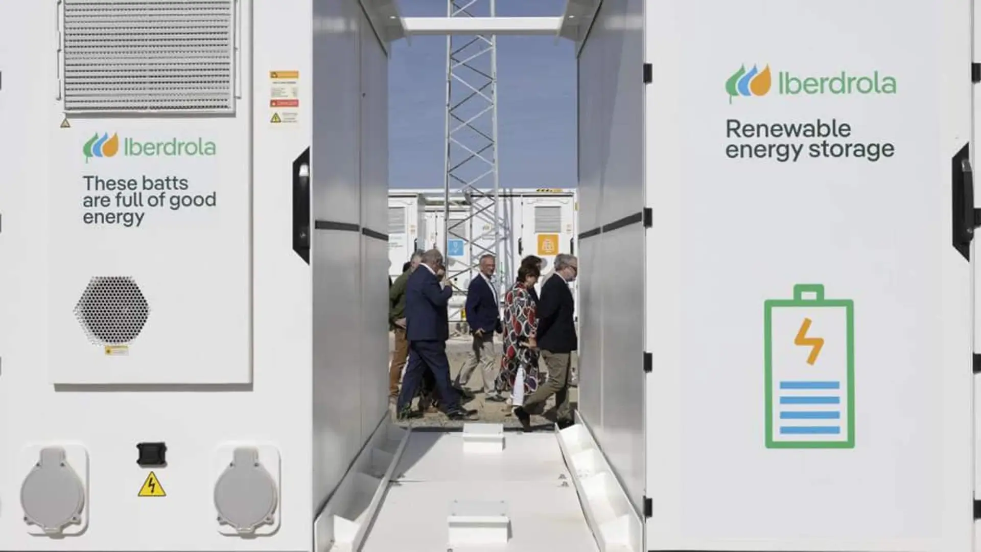 Iberdrola enciende en Cáceres la mayor batería de España y acerca la energía firme a miles de hogares Pasillo entre contenedores de almacenamiento renovable de Iberdrola con varias personas al fondo
