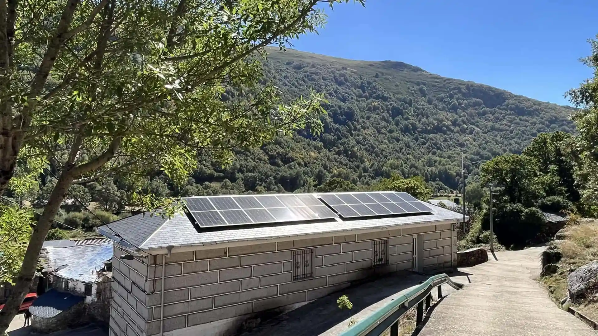 Instalación de paneles solares en el tejado de un edificio en un pueblo de montaña.