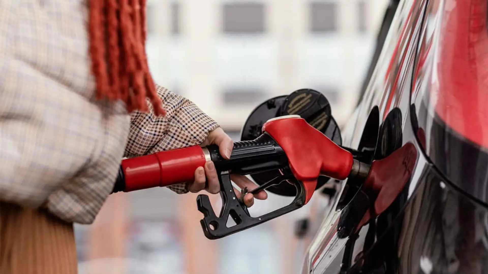 Si tienes un coche diésel o gasolina, prepárate: estos son los cambios que afectarán a tu bolsillo en 2026 Persona repostando gasolina en un coche en una estación de servicio