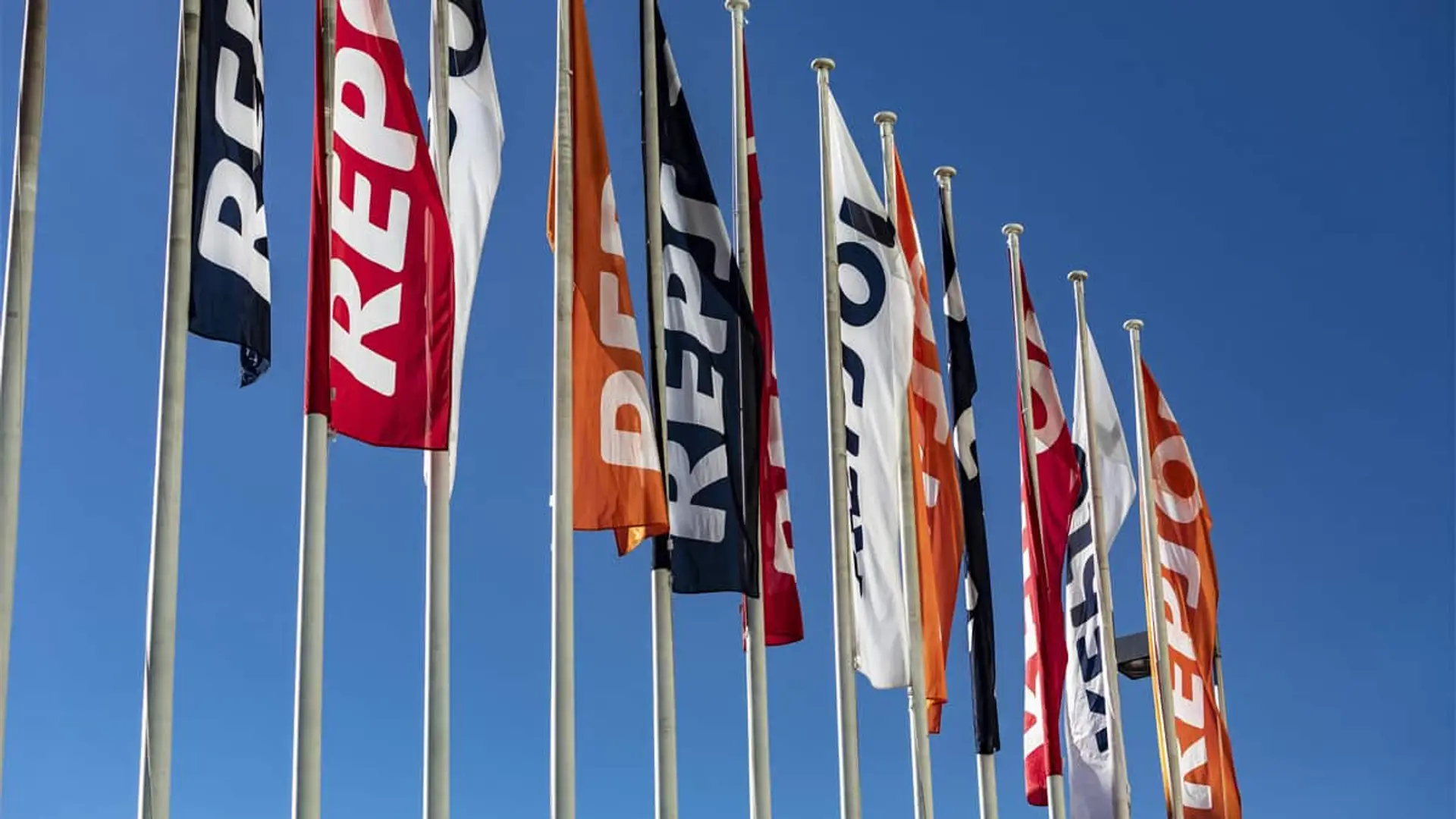 Banderas de Repsol ondeando frente a la sede corporativa de la compañía
