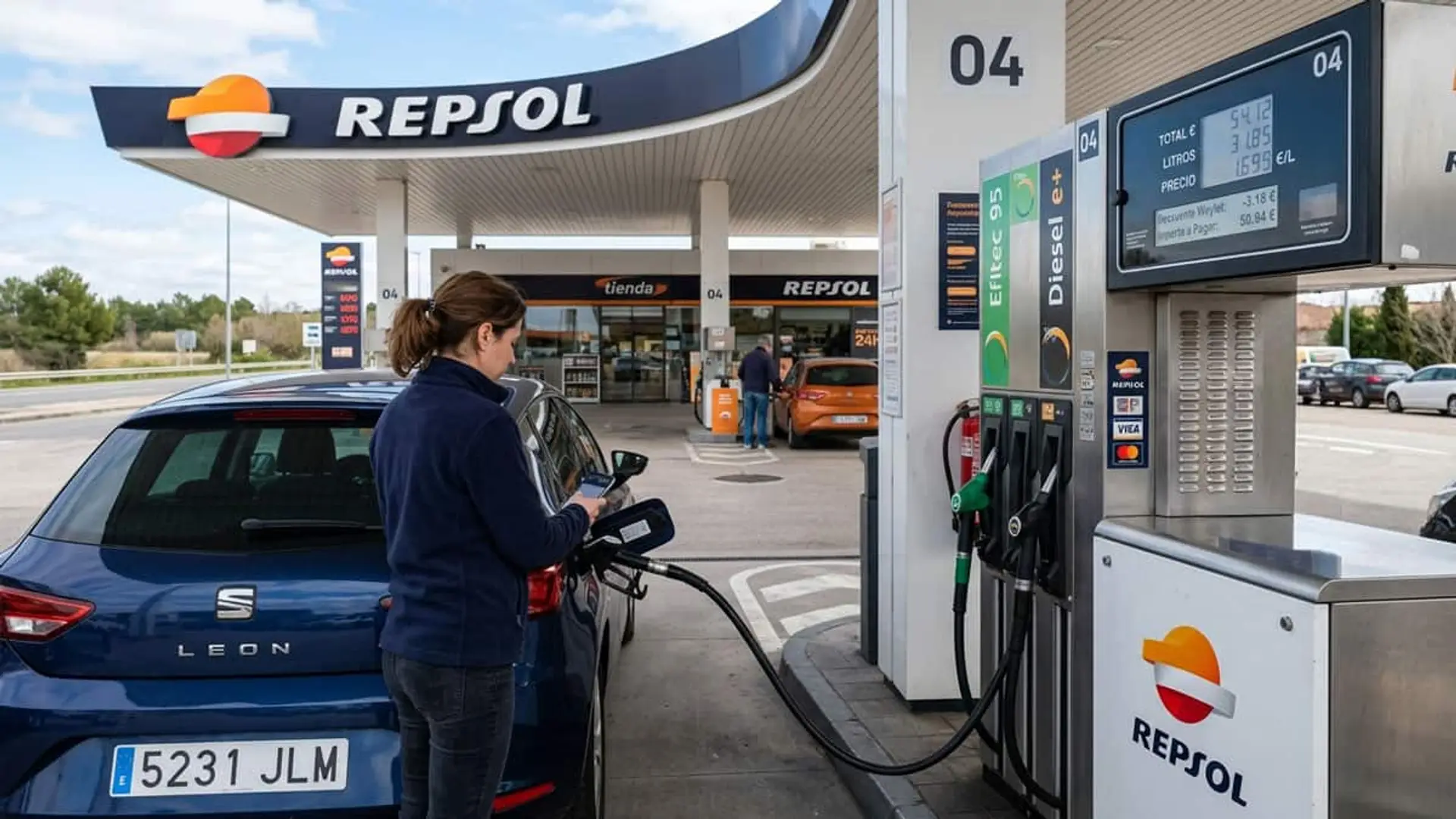 Mujer repostando un coche en una gasolinera Repsol mientras utiliza el móvil junto a un surtidor con Waylet