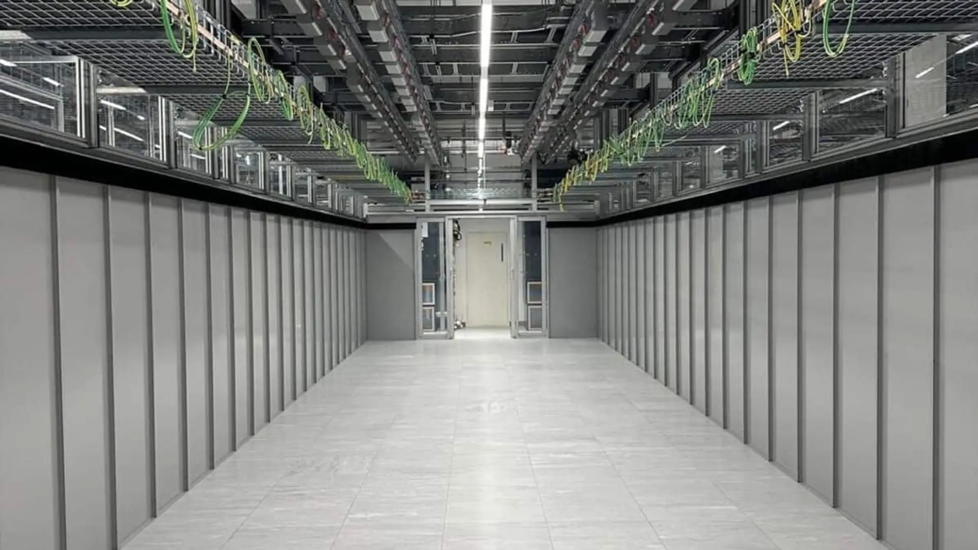 Sala técnica de un centro de datos con cableado superior y espacio preparado para instalar racks de servidores.