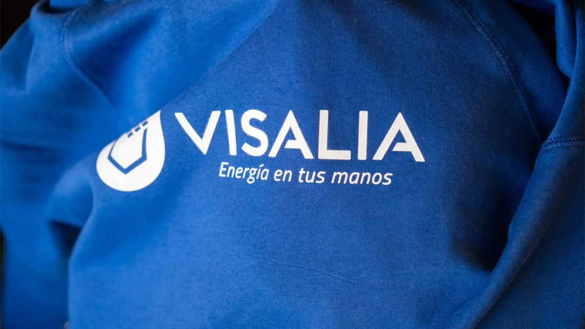 Primer plano de una sudadera azul con el logotipo de Visalia y el texto Energía en tus manos