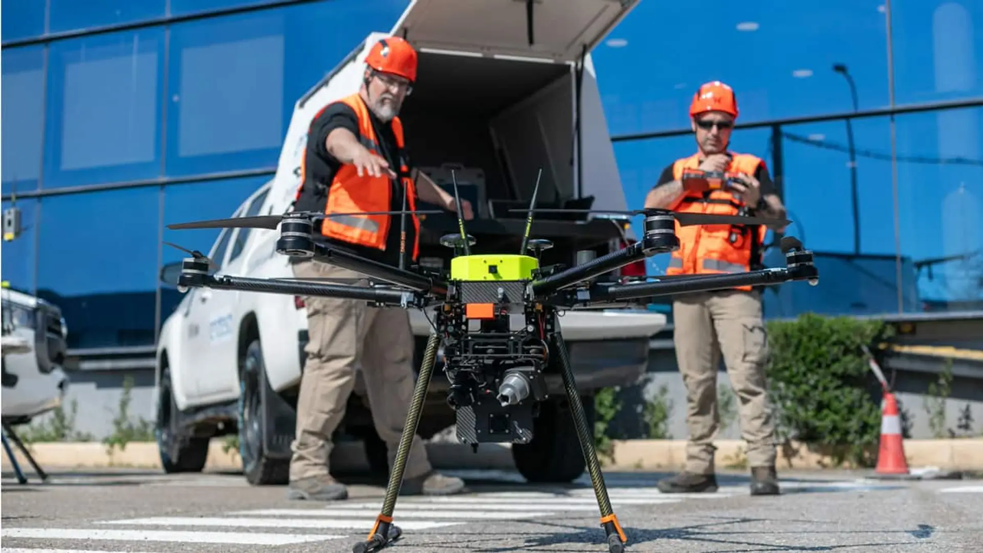 Dos técnicos de Endesa junto a una furgoneta preparando un dron.
